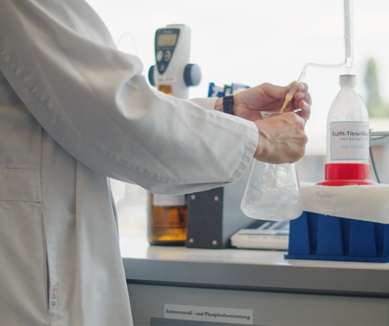 Chemielaborantin im Labor mit Becherglas